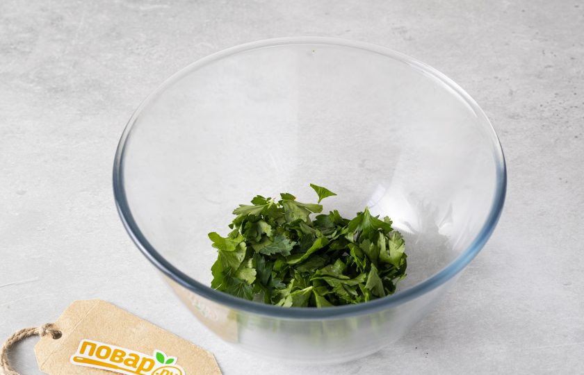 1. Этап. Салат с баклажанами и вялеными помидорами: Листья петрушки отделите от стеблей, крупно порубите или порвите руками. Переложите в глубокую миску.