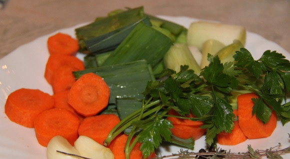 1. Этап. Стерлядь на шампанском: 2. Обязательно используйте по рецепту приготовления стерляди на шампанском овощи : сельдерей, лук-порей, морковь, зелень, чеснок. Все, что сделает бульон более ароматным и вкусным. Очистите и вымойте все ингредиенты, выложите вместе с рыбкой в подходящую кастрюлю или в сотейник.