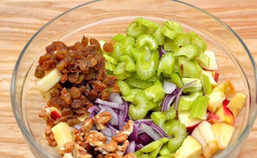 1. Этап. Салат с сельдереем стеблевым: В салатницу добавьте нарубленный орех, нарезанный сельдерей и лук, а также изюм.