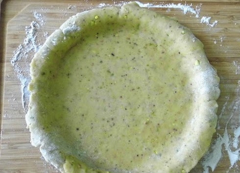 1. Этап. Фисташковый тарт с белым шоколадом: 6. После раскатайте тонко и выложите в жаропрочную форму. Сверху поместите лист пергамента и утяжелитель (фасоль или горох), например. При температуре 200 градусов выпекайте корж 20 минут. Потом уберите утяжелитель и запекайте еще 7-10 минут.