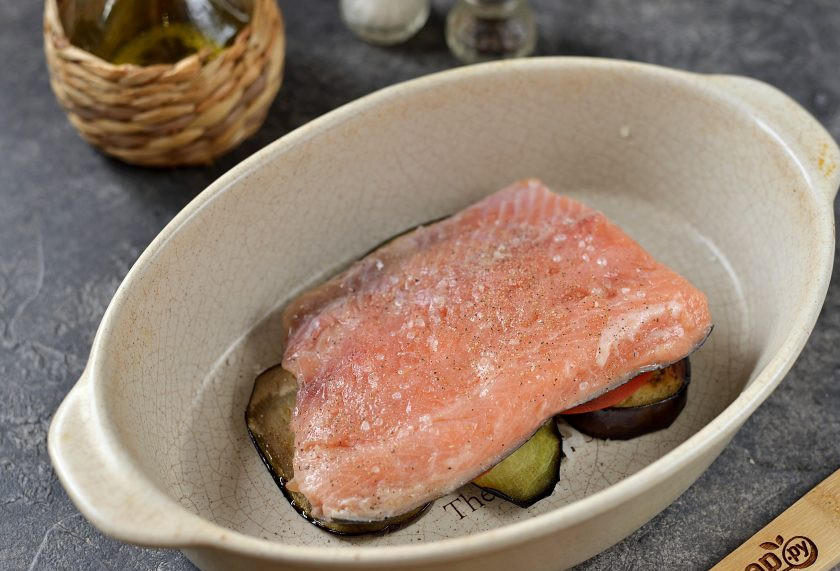 1. Этап. Форель с баклажанами в духовке: Сверху на овощи выложите филе форели, посолите и поперчите, сбрызните лимонным соком.