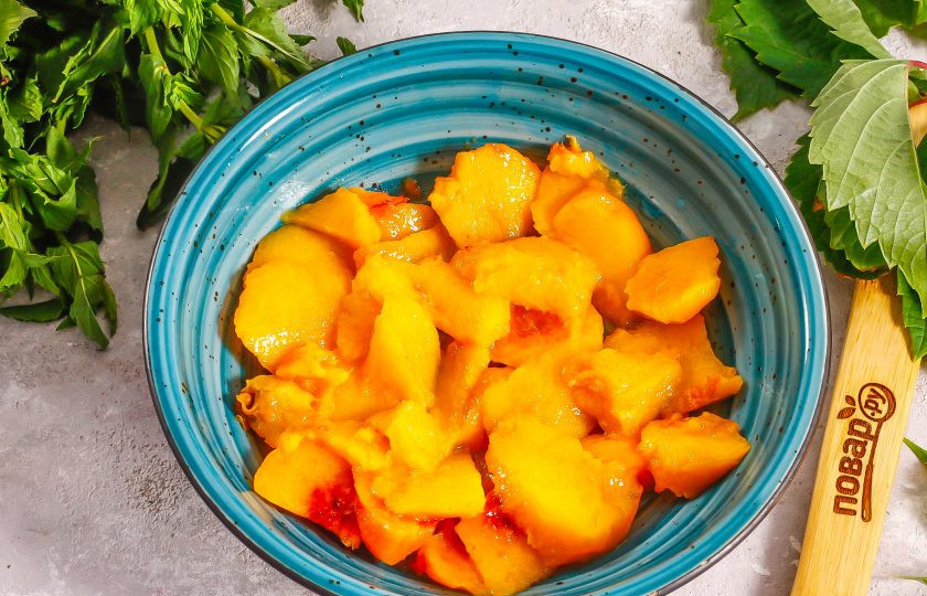 1. Этап. Кабачки в персиковом соке на зиму: Персики ошпарьте кипятком и счистите с плодов кожуру. Нарежьте мякоть ломтиками.