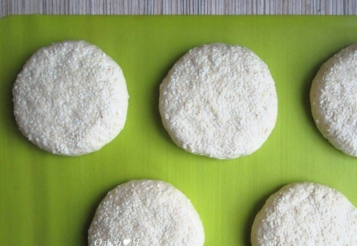 1. Этап. Чикенбургер с сыром и баклажанами: Смажьте булочки молоком и посыпьте кунжутом. Придавите по всей поверхности, чтобы булочки стали плоскими, диаметром около 8-10 см.