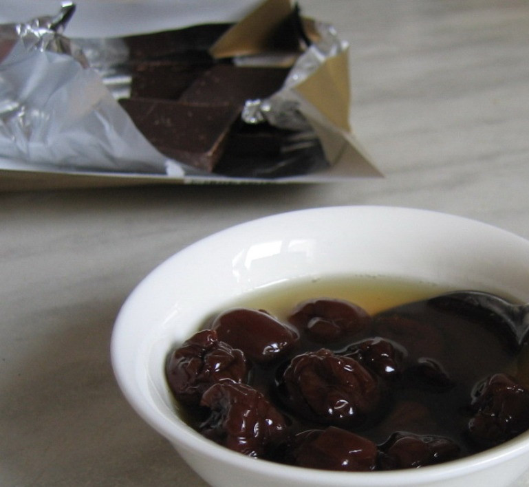 1. Этап. Пьяная вишня в шоколаде: 2. Заранее готовим сироп: в сотейник наливаем четверть стакана воды и кладем сахарный песок, отправляем массу на огонь и варим. В чашке смешиваем 2 столовые ложки холодной воды с крахмалом. Переливаем содержимое чашки в сотейник и варим 3 минуты на слабом огне. Немного остужаем полученную массу и вливаем коньяк, затем добавляем ягоды из настойки. Оставляем на 1 час.