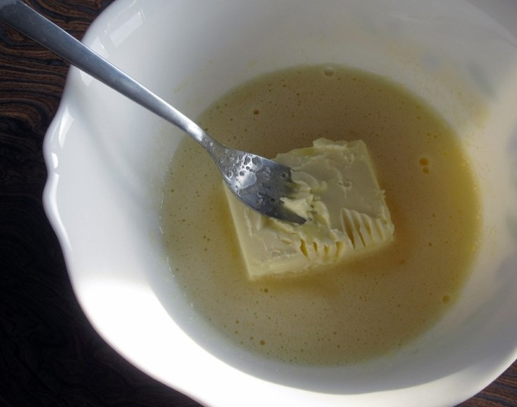 1. Этап. Кексы простые на кефире: 3. В яичную массу добавляем мягкое сливочное масло, продолжаем все взбивать.