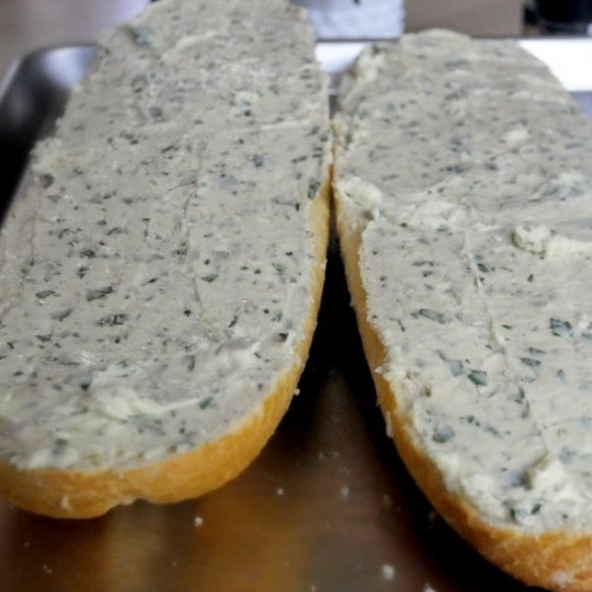 1. Этап. Чесночно-сырные гренки: Щедро намазываем на половинки хлеба получившуюся сырно-масляную массу.