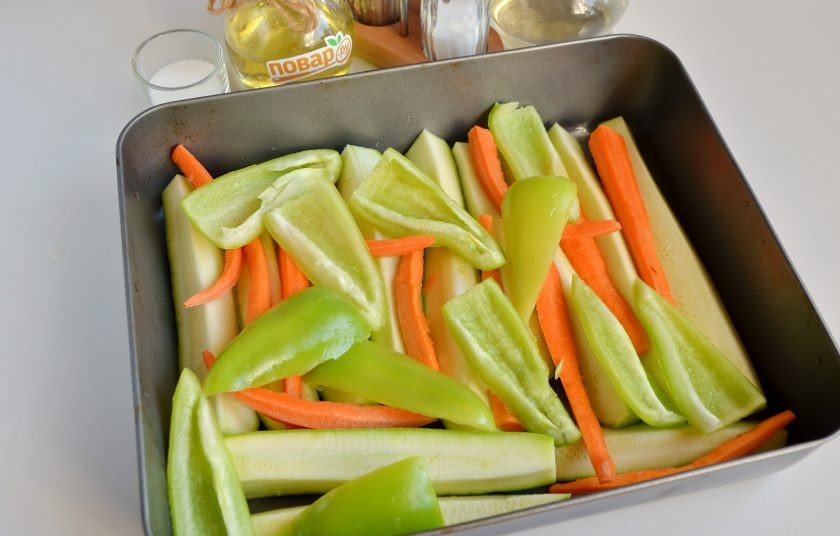 1. Этап. Кабачковая икра в духовке на зиму: 2. Вымойте кабачки, обрежьте хвостики, порежьте на 4 части вдоль. Морковь очистите, порежьте на 4 части вдоль, как кабачки. Сладкий перец вымойте, удалите семена, сполосните внутри и порежьте на 4 части. Смажьте маслом растительным противень глубокий, выложите овощи произвольно, я обычно кладу на низ кабачки, потом морковь, сверху перец.