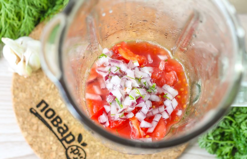 1. Этап. Гаспачо по-андалузски: Помидоры залейте кипятком и оставьте на 5-6 минут, затем очистите их от кожуры, вырезая зеленые сердцевинки. Нарежьте мякоть ломтиками в чашу блендера или измельчителя. Очистите и промойте красный лук, нарежьте его половину кубиками и добавьте в емкость.