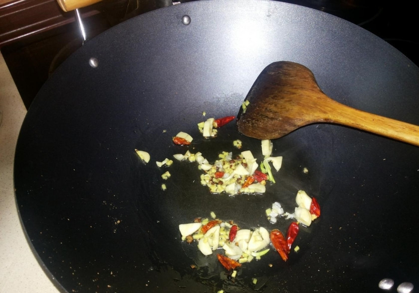 1. Этап. Салат из портулака: 3. Нарезаю чеснок обычный кусочками, к нему добавляю сычуаньский перец, сушенный перец чили и немного имбиря. В вок наливаю немного масла и отправляю на огонь, выкладываю все порезанные приправы и обжариваю 1-2 минуты.