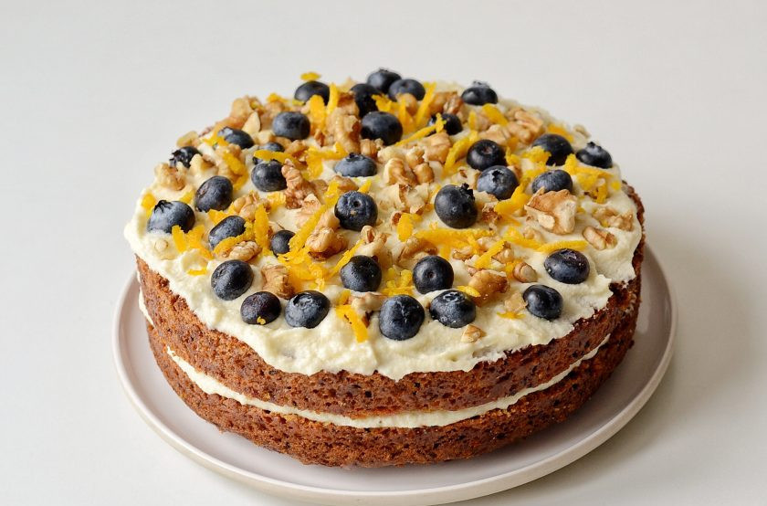 1. Этап. Морковный торт без яиц: Накройте второй половиной бисквита, смажьте ее оставшимся кремом. Сверху украсьте ягодами, апельсиновой цедрой и грецкими орехами.