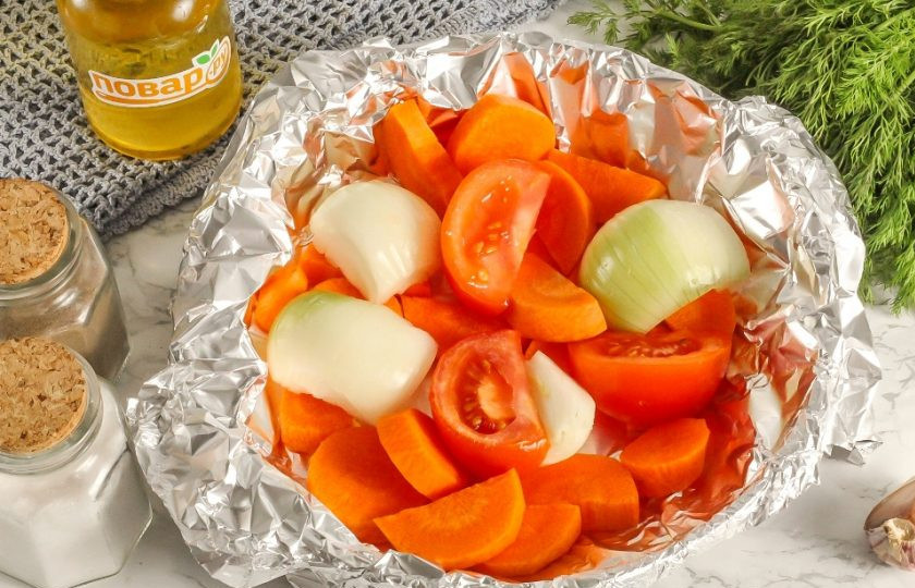 1. Этап. Колбаски «По-балкански» с салатом из запеченных овощей: Очистите морковь от кожуры и промойте. Нарежьте крупными ломтиками морковь, лук и помидор. Выложите в фольгу и сбрызните растительным маслом, посолите. Закройте фольгу так, чтобы не было отверстий. Разогрейте духовку и запеките овощи примерно 15-20 минут при 180 градусах.