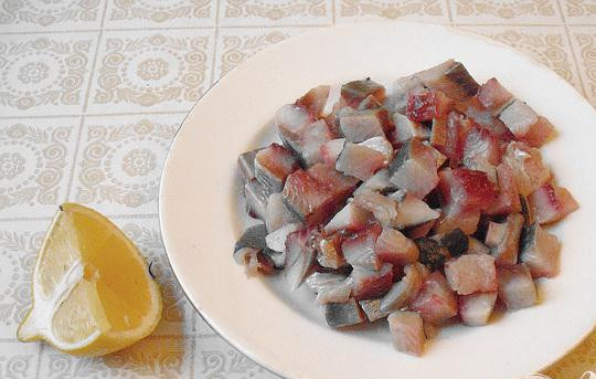 1. Этап. Салат Мимоза с сельдью: 2. Выпотрошим селедку, удаляем голову и снимаем кожу. Кости отделяем от мякоти. Убираем даже самые маленькие кости, мелкими кубиками нарезаем мякоть. Тоненьким слоем рыбу распределяем на блюде, сбрызгиваем лимонным соком.