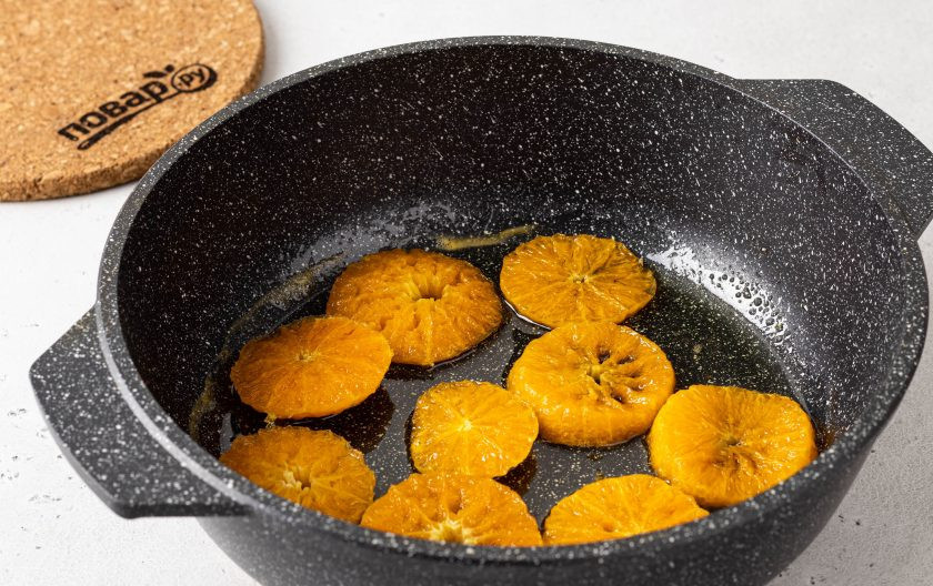 1. Этап. Постный пирог с мандаринами: Соедините в сковороде 50 грамм сахара и 50 мл. воды, доведите до кипения и дождитесь, когда сахар полностью растворится. В этом сиропе потомите мандарины 5-6 минут с двух сторон.