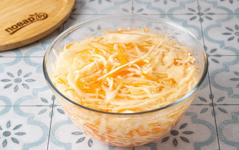 1. Этап. Салат из свежей капусты и моркови: Перемешайте. Влейте кипяток, чтобы вода покрывала овощи. Оставьте на 1 минуту. Так капуста будет сочнее, но останется хрустящей.