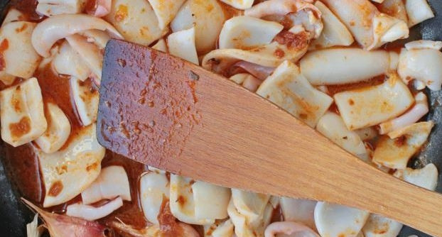 1. Этап. Салат из кальмара с огурцом: Зубчики чеснока раздавите лезвием ножа. Влейте в сковородку оливковое масло, разогрейте его, обжарьте в нем зубчики чеснока. Затем выложите в сковороду подготовленные кальмары и положите к ним соус 