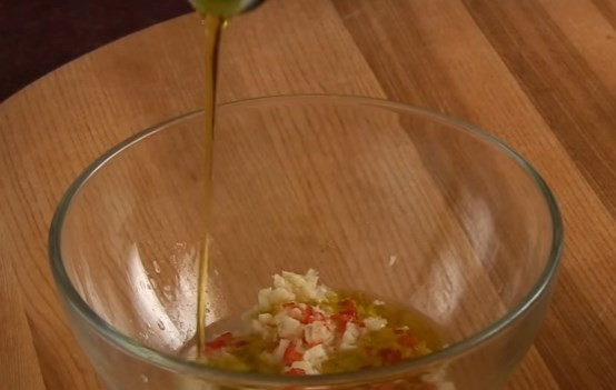 1. Этап. Острый овощной салат из дайкона: 5. Для приготовления заправки мелко нарежьте чеснок и красный острый перец. Выдавите сок из половины лимона и добавьте оливковое масло.