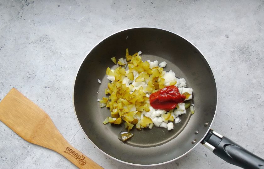 1. Этап. Солянка Селянка: Лук и соленый огурец мелко нарежьте. Выложите в сковороду, добавьте томатную пасту.