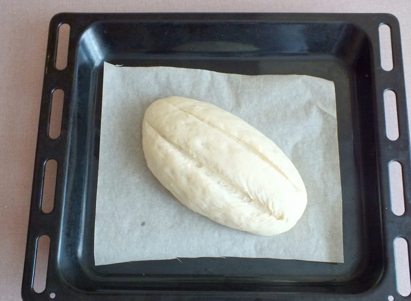 1. Этап. Батон Подмосковный: Разогрейте духовку до 230 градусов. Нагрейте в ней противень. Поставьте в духовку чашу с водой для создания пара. Заготовку батона перенесите на горячий противень. Сделайте два продольных неглубоких разреза. Поставьте в духовку. Выпекайте с паром 10 минут. После достаньте чашу с водой, снизьте температуру до 180 градусов и выпекайте еще 11 минут.