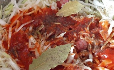 1. Этап. Тушеная капуста с колбасками: Теперь добавим томатную пасту. Если в капусте много сока - разводить пасту не надо. Если мало - добавьте немного воды. Добавляем перец и лавровый лист. Перемешиваем и тушим еще минут 30 на маленьком огне. Не забываем периодически перемешивать.