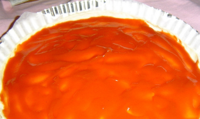 1. Этап. Сырная пицца: Заготовку для пиццы немного смочите в воде, затем уложите в формочку для выпечки. Сверху смазываем заготовку томатной пастой.