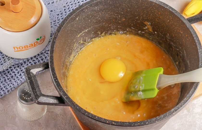 1. Этап. Медовик с вареной сгущенкой и сметаной: Затем по одному вбейте в емкость куриные яйца и тщательно вымешайте тесто. После чего досыпьте пшеничную муку, оставляя немного на раскатку.