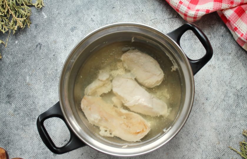 1. Этап. Салат с говяжьим языком и курицей: Пока варится язык, отварите курицу. Для этого мясо промойте и выложите в кастрюлю, залейте холодной водой, посолите и доведите до кипения на среднем огне. Снимите пену, которая образуется во время кипения, и варите в течение 20-30 минут, до готовности. Снимите кастрюлю с огня и остудите курицу, положив в пакет.