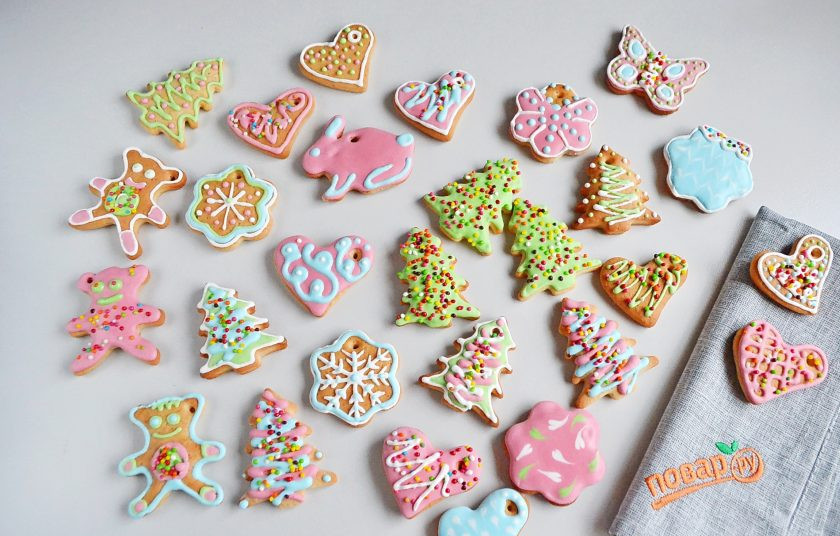 1. Этап. Печенье Елочные игрушки: Мы с дочкой постарались сделать разные варианты. Какие фигурки покрывали полностью глазурью и посыпали посыпкой, после застывания белка все отлично держится. Какие-то мы просто разрисовывали. Готовое печенье нужно оставить на несколько часов для застывания глазури, а лучше на ночь. В полностью готовое печенье проденьте ниточки — и украшайте ёлку!