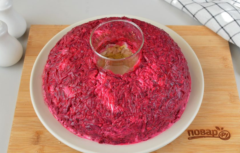 1. Этап. Салат Гранатовый браслет с курицей и яблоком: Свеклу натрите на крупной терке, отожмите от сока, если его много. Смешайте ее с измельченным чесноком, солью, перцем, ложкой майонеза. Распределите свеклу.