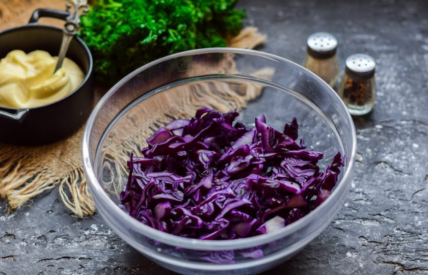 1. Этап. Салат с краснокочанной капустой и кукурузой: Красную капусту сполосните и просушите, после нарежьте тонкой полоской. Выложите капусту в салатник.