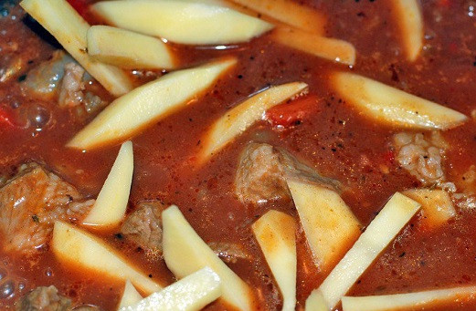 1. Этап. Перкельт из свинины: 7. Картофель вымыть, очистить и нарезать средними брусочками. К уже мягкому мясу добавить картофель и тушить до готовности.