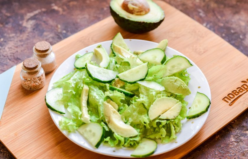 1. Этап. Салат с форелью и авокадо: На листья выложите авокадо и огурцы.