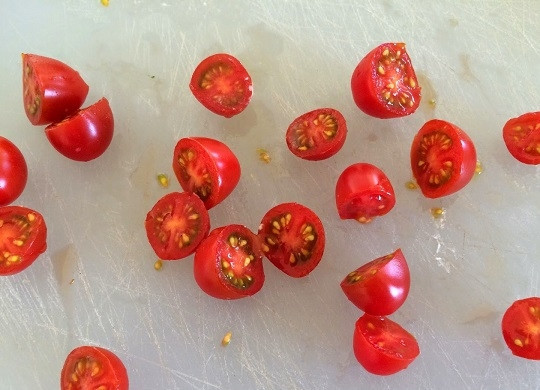 1. Этап. Новогодняя закуска Капрезе: 2. Нарежьте половинками вымытые и обсушенные помидорки.