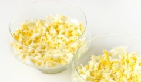 1. Этап. Салат с курицей в креманках: Собираем салат. На дно стеклянных креманок выкладываем первым слоем измельчённые куриные яйца.