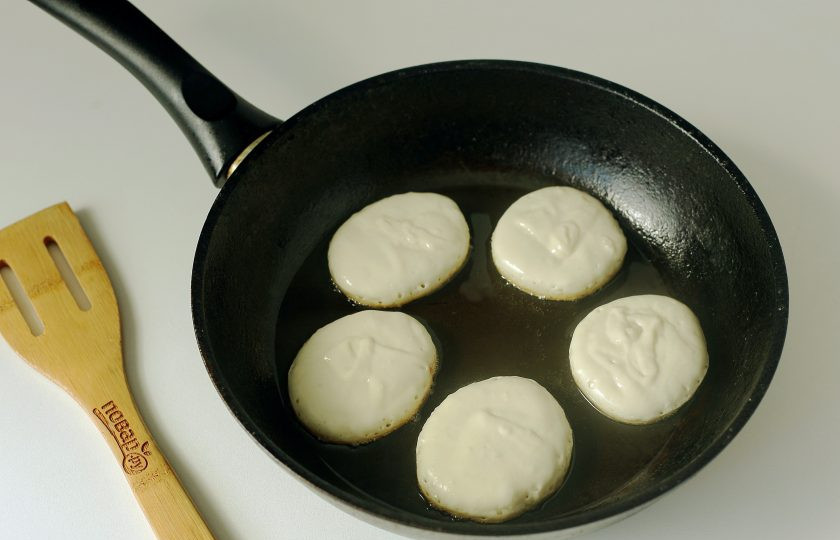 1. Этап. Оладьи на кефире с крахмалом: Разогрейте сковороду с маслом и выкладывайте тесто при помощи столовой ложки.