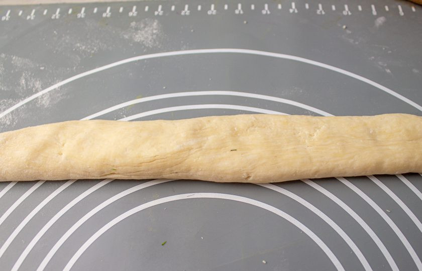 1. Этап. Творожные рогалики с вишней: Достаньте тесто из холодильника, разделите на 2-3 части. Скатайте из каждого кусочка жгут. Для раскатки используйте отложенную муку.