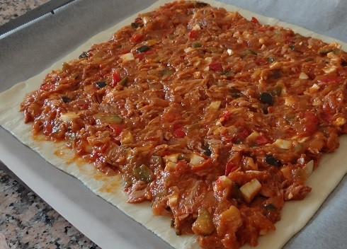 1. Этап. Слоеный пирог с тунцом: Начинку распределяем ровным слоем, немного не доходя до краев пласта теста.