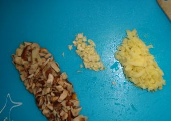 1. Этап. Кальмары в воке: Очищаем имбирь и чеснок. Трем имбирь на терке, чеснок мелко рубим. Грибы нарезаем на небольшие кусочки.