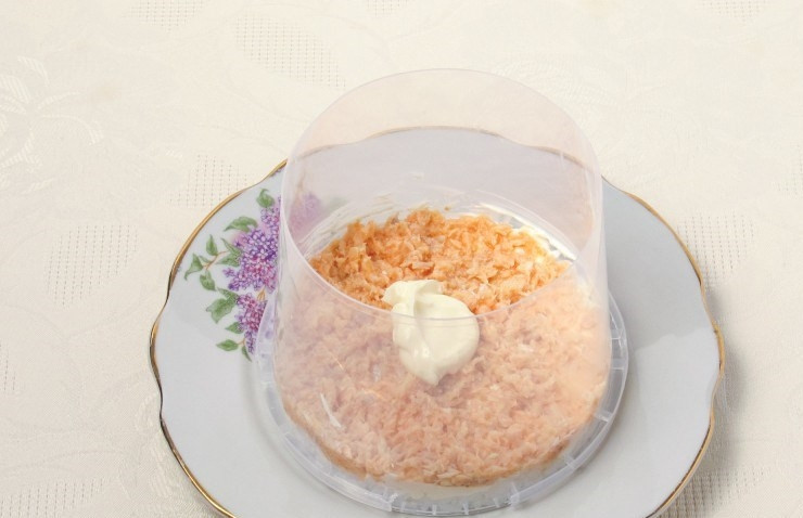 1. Этап. Салат Мимоза (рецепт с рисом): Откройте рыбную консерву, слейте лишнюю жидкость. Достаньте косточки. Помните вилкой рыбную консерву и выложите слой консервы поверх риса. Снова смажьте слой майонезом.