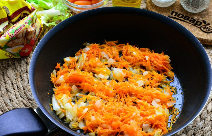 1. Этап. Печеночные ежики: Сковороду смажьте растительным маслом, выложите овощи и обжаривайте лук с морковкой пару минут до мягкости.