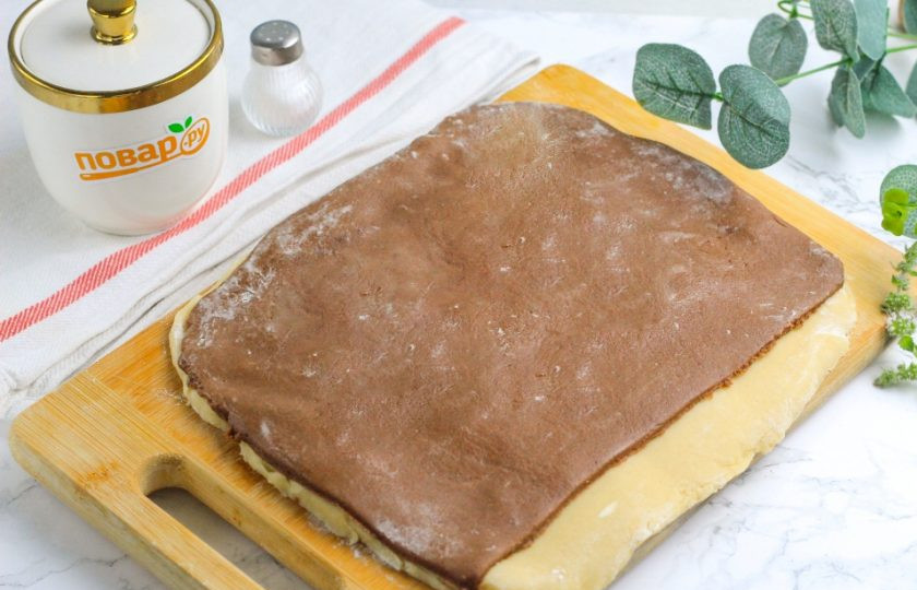 1. Этап. Шоколадно-ванильное печенье: Аккуратно раскатайте в прямоугольный пласт сначала ванильное тесто, а затем — шоколадное. Выложите шоколадное сверху на ванильное и прировняйте края, подрезая их ножом.