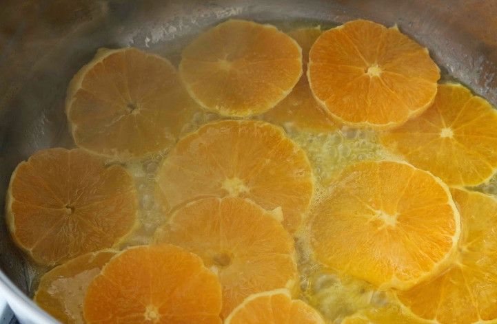 1. Этап. Пирог из апельсинов: Выложите в сироп очищенные и порезанные кружочками около 1 см толщиной апельсины. На медленном огне нужно карамелизировать цитрусовые. В процессе карамель должна обволакивать апельсины. Это займет 20-25 минут.