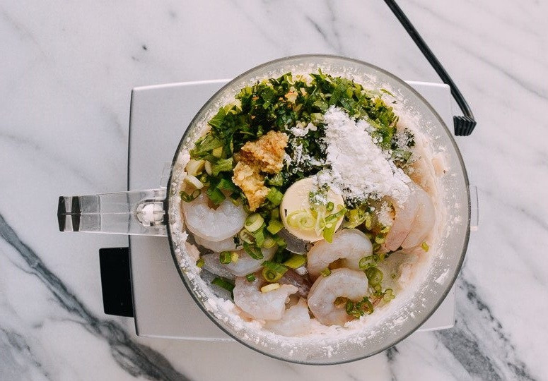 1. Этап. Гренки с креветками по-китайски: 1. В чашу комбайна добавьте очищенные креветки, свиной жир, веточки кинзы, тертый имбирь, измельченный лук, кунжутное масло, сахар, соль, крахмал, куриный белок.