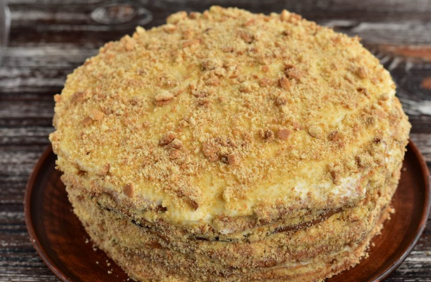 1. Этап. Медовик с бананом и киви: Измельчите корж для украшения в крошку. Посыпьте торт сверху и продекорируйте края.