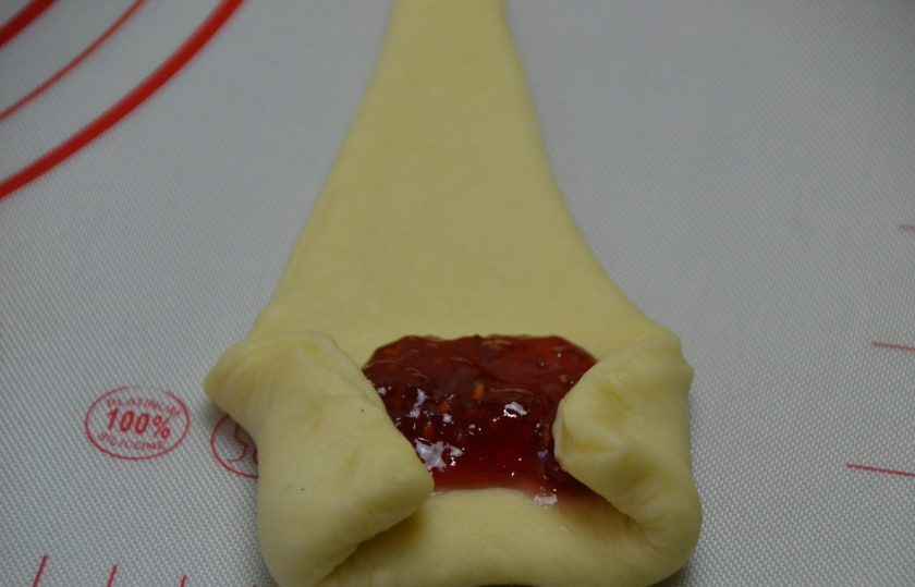 1. Этап. Польские булочки: На широкий край треугольника из теста выложите джем. Подверните края к центру, это нужно для того, чтобы начинка не вытекала, а осталась внутри булочки.
