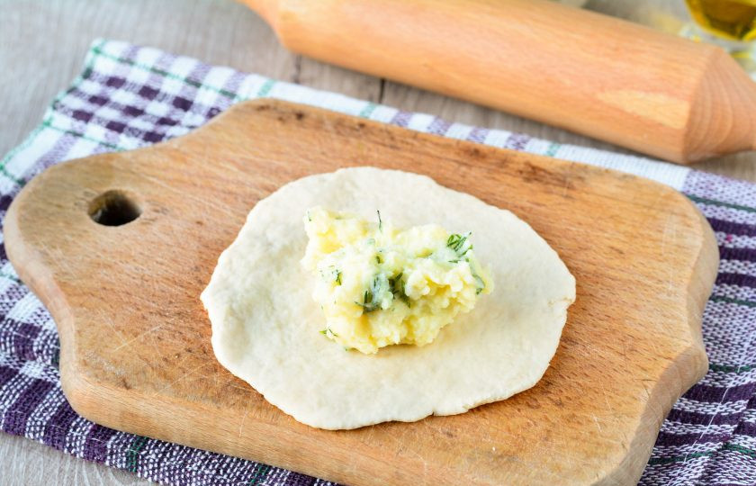 1. Этап. Жареные пирожки на заварном тесте: Выложите в центр картофельную начинку — примерно 1 ст. л.