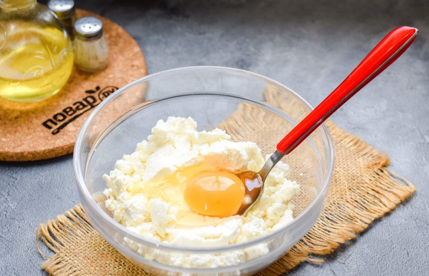 1. Этап. Сырники с маскарпоне: Следом добавьте к творогу одно куриное яйцо.