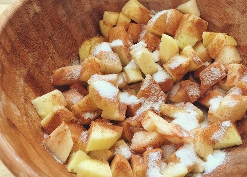 1. Этап. Штрудель яблочный из готового слоеного теста: Выложим нарезанные яблоки в миску, добавим 2 столовые ложки белого сахара, корицу и муку. Перемешаем и пусть постоят минут 15.