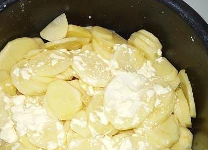 1. Этап. Жаркое из свинины в мультиварке: Режем кружочками картофель и кладем сверху на томаты. Солим и заливаем сметаной и водой.