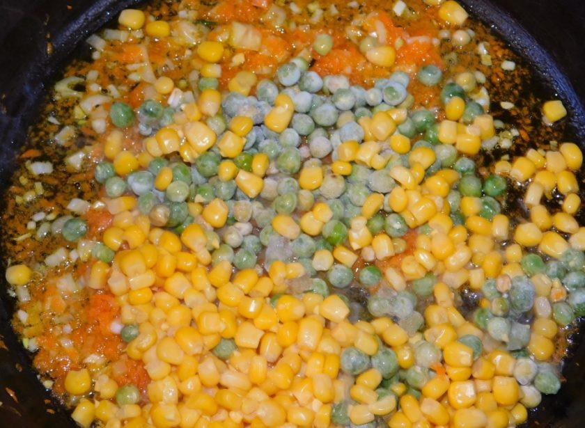 1. Этап. Рисовый гарнир с горошком и кукурузой: Добавьте в сковороду горошек и кукурузу. Обжарьте все вместе, чтобы горошек успел разморозиться.