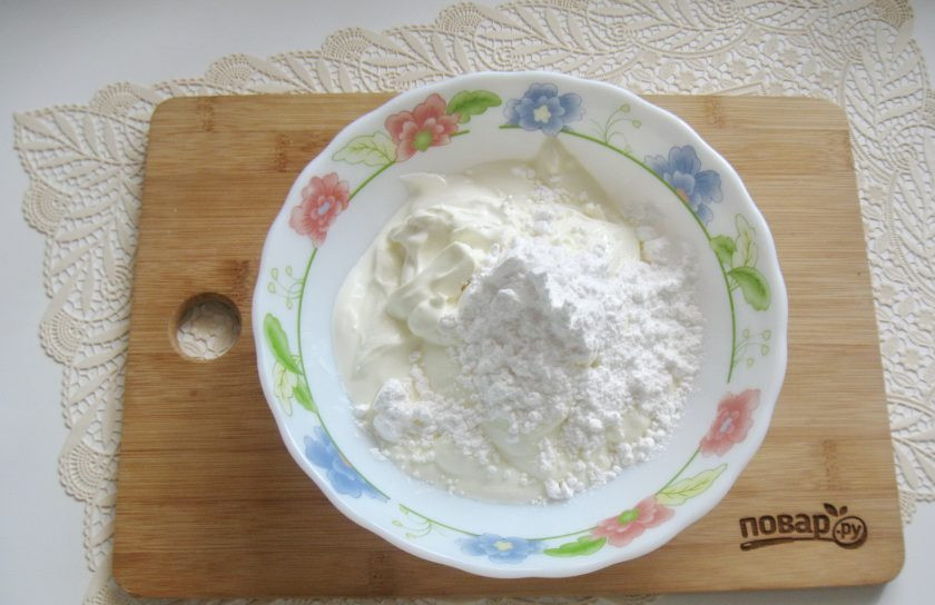 1. Этап. Сметанный торт с медовыми коржами: Приготовьте крем. В миску выложите сметану и добавьте сахарную пудру и ванильный сахар.